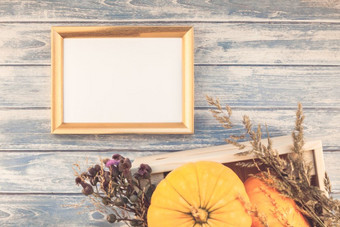 前视图秋天橙色南瓜和干花与草感恩节背景在蓝色的健美的木表格与金框架模拟和复制空间乡村风格模板为文本