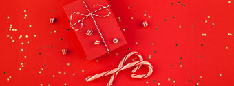 新一年圣诞节礼物包装丝带平躺前视图圣诞节假期庆祝活动手工制作的礼物盒子红色的纸金闪光背景模板模型问候卡长宽横幅