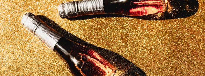 圣诞节新一年作文与瓶玫瑰香槟金闪亮的背景前视图与黑暗阴影庆祝活动平躺聚会，派对有创意的概念
