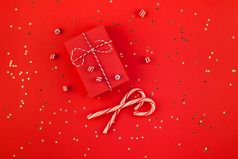 新一年圣诞节礼物包装丝带平躺前视图圣诞节假期庆祝活动手工制作的礼物盒子红色的纸金闪光背景模板模型问候卡你的文本设计