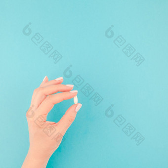 女人手持有白色药丸柔和的蓝色的纸背景与复制空间最小的风格广场模板为文本概念医疗治疗药店医疗保健