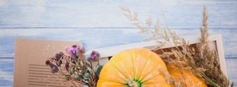 前视图秋天橙色南瓜和干花和草盒子感恩节背景在蓝色的健美的木表格与复制空间模板为秋天收获情绪文本长宽横幅