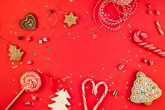 新一年圣诞节装饰平躺前视图圣诞节假期庆祝活动手工制作的装饰木玩具糖果金星星闪闪发光的红色的纸背景模板框架为问候卡你的设计