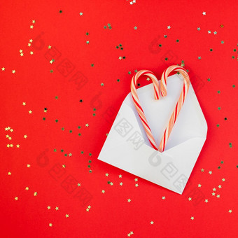 新一年圣诞节装饰平躺前视图圣诞节假期庆祝活动手工制作的装饰糖果金星星闪闪发光的红色的纸背景广场模板框架为问候卡你的设计
