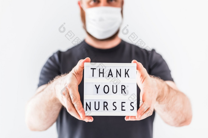 护士一天概念男人。手持有lightbox与文本谢谢你的护士感谢医生护士和医疗工作人员工作医院在冠状病毒新冠病毒大流行