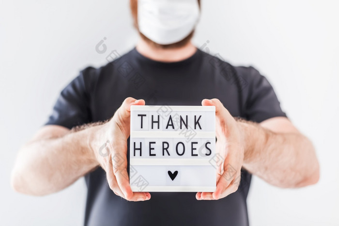 护士一天概念男人。手持有lightbox与谢谢英雄文本感谢医生护士和医疗工作人员工作医院在冠状病毒新冠病毒大流行