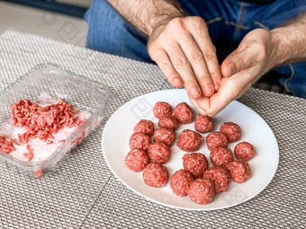 男人。手准备肉丸与生甜馅生活方式关闭作文与自然光自制的烹饪在封锁保持首<strong>页</strong>管家<strong>分享</strong>概念一边视图