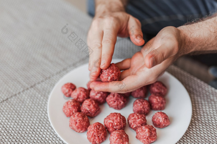 男人。手准备肉丸与生甜馅生活方式关闭作文与自然光自制的烹饪在封锁保持首页管家分享概念以上视图与复制空间