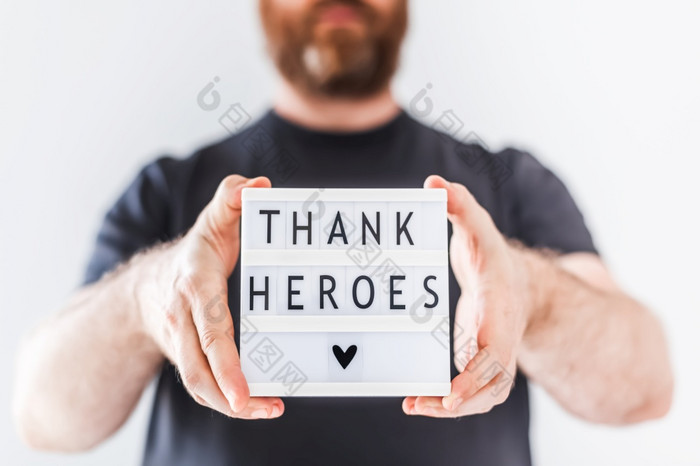 护士一天概念男人。手持有lightbox与谢谢英雄文本感谢医生护士和医疗工作人员工作医院在冠状病毒新冠病毒大流行