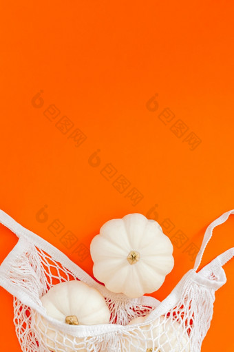 秋天平躺作文与白色南瓜网购物袋大胆的橙色颜色背景有创意的秋天感恩节秋天万圣节概念零浪费风格前视图复制空间