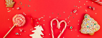 新一年圣诞节装饰平躺前视图圣诞节假期庆祝活动手工制作的装饰木玩具糖果金星星闪闪发光的红色的纸背景模板框架长宽横幅