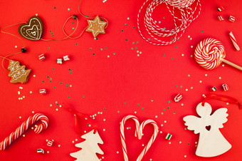 新一年圣诞节装饰平躺前视图圣诞节假期庆祝活动<strong>手工</strong>制作的装饰木玩具糖果金星星闪闪发光的红色的纸背景<strong>模板</strong>框架为问候卡你的设计