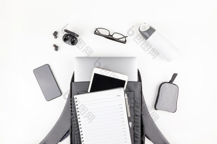 有创意的前视图平躺开放背包与移动PC和平板电脑内部移动电话复制空间白色背景最小的风格概念现代男人。配件为教育业务和生活