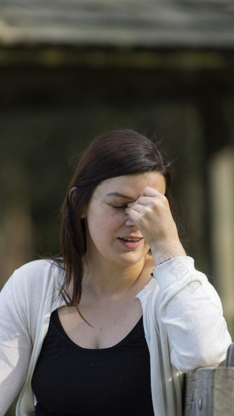 肖像美丽的年轻的<strong>拉美</strong>裔女人与长头发与担心的态度对背景无重点绿色树在日落肖像美丽的年轻的<strong>拉美</strong>裔女人与长头发与担心的态度对背景无重点绿色树