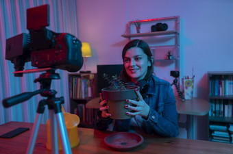 美丽的拉美裔女人前面视频相机记录博客她的工作室与红色的和蓝色的灯内部她的房子广播她的园艺评论社会媒体美丽的拉美裔女人前面视频相机记录博客她的工作室与红色的和蓝色的灯内部她的房子