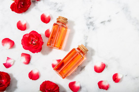 香水玫瑰水玻璃瓶和小的玫瑰与花瓣复制