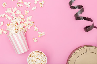 爆米花桶电影带和电影可以粉红色的背景电影背景前视图复制空间