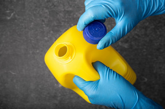 人类手保护手套开放黄色的漂白剂瓶<strong>消毒</strong>概念