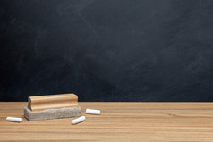 回来学校背景概念粉笔和橡皮擦木桌子上和黑板背景复制空间