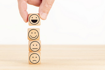 <strong>客户服务</strong>评价和满意度调查概念手选的快乐脸表情符号木块复制空间
