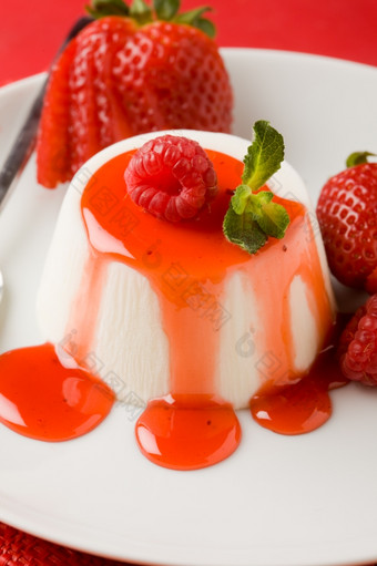 照片意大利潘纳白色短衣甜点与草莓糖浆而且薄荷叶