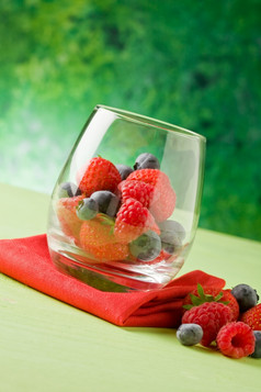 照片美味的浆果内部水晶玻璃前面绿色背景