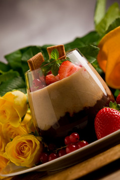巧克力榛子摩丝与浆果前面玫瑰背景