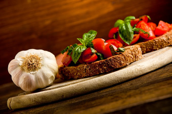 照片美味的意式烤面包片开胃菜与新鲜的把西红柿而且罗勒