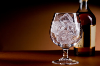 <strong>照片</strong>美味的玻璃白兰地威士忌与冰多维<strong>数据</strong>集棕色（的）背景