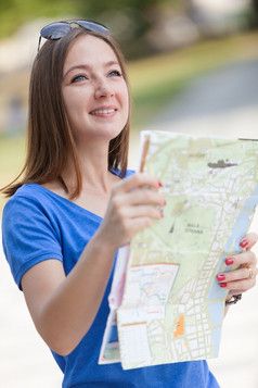 照片微笑女人与的地图旅游概念