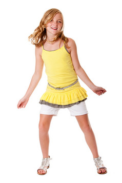 美丽的可爱的金发碧眼的女孩有有趣的跳舞时尚穿着分层黄色的衬衫白色短裤而且带孤立的