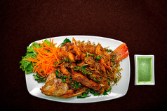 炸新鲜的大鱼与沙拉和热辣的酱汁泰国食物风格概念