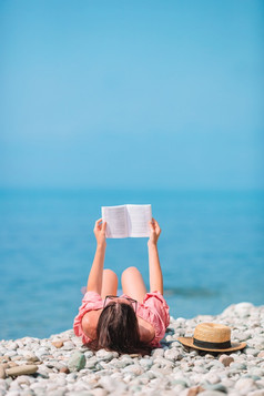 年轻的女人阅读书的海滩和享受夏天假期年轻的女人阅读书在热带白色海滩