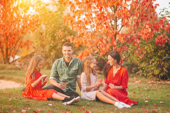年轻的家庭与小孩子们秋天公园阳光明媚的一天家庭秋天肖像肖像快乐家庭四个秋天一天