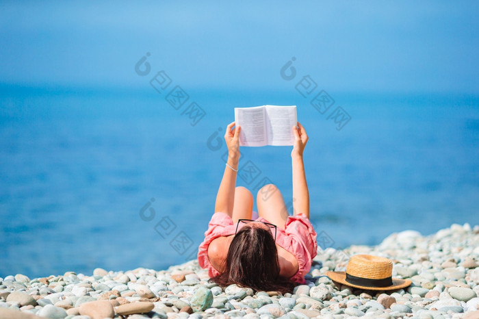 年轻的女人阅读书的海滩年轻的女人阅读书在热带白色海滩