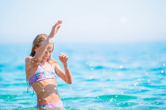 <strong>小孩</strong>子游泳清晰的Turquiose海洋可爱的小女孩海滩在<strong>夏天</strong>假期