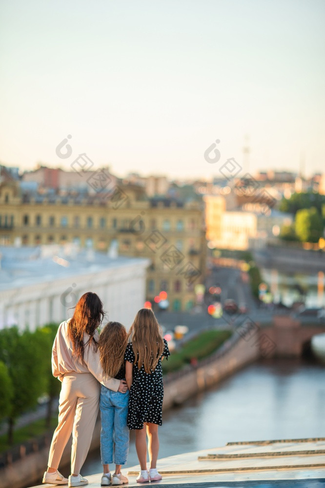 年轻的家庭妈妈和孩子们屋顶享受与视图美丽的日落欧洲城市家庭屋顶享受与视图美丽的日落圣人彼得堡俄罗斯