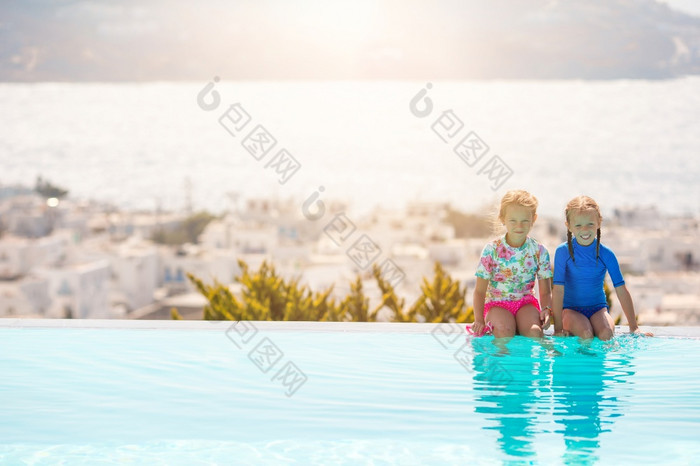可爱的小女孩的边缘户外池他们的夏天假期希腊可爱的小姐妹海滩在夏天假期