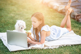 小女孩使用移动PC研究在户外的公园小女孩在户外的公园与电脑
