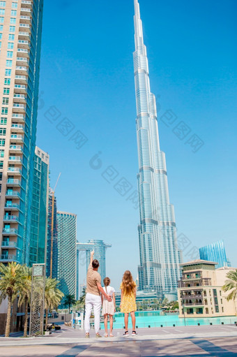 家庭父亲和孩子们迪拜与摩天大楼的背景视图从后面快乐家庭走迪拜与迪拜塔<strong>哈利</strong>法塔摩天大楼的背景