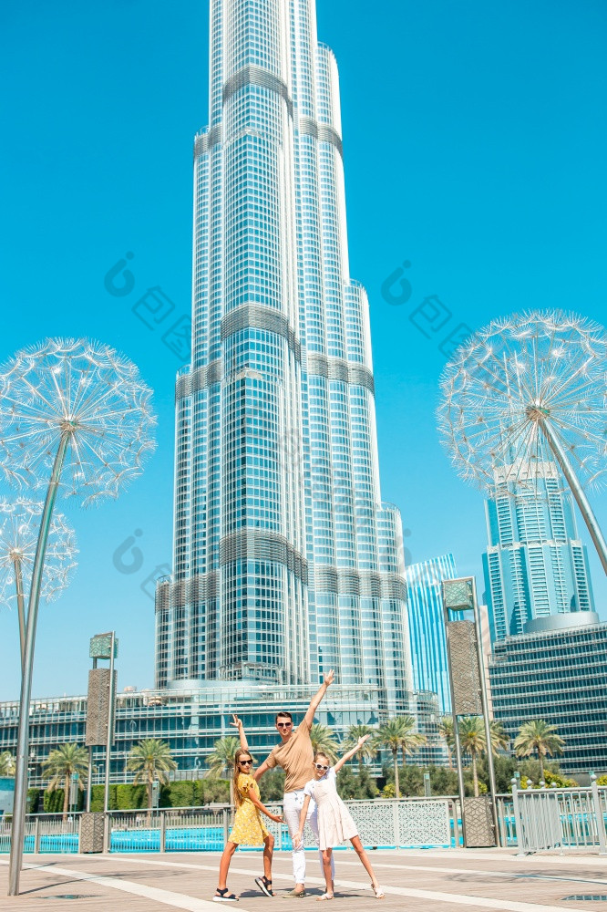 迪拜曼联阿拉伯阿联酋航空公司2月家庭父亲和孩子们迪拜与摩天大楼的背景视图从后面快乐家庭走迪拜与迪拜塔哈利法塔摩天大楼的背景