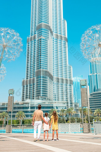 迪拜曼联阿拉伯阿联酋航空公司2月家庭父亲和孩子们迪拜与摩天大楼的背景视图从后面快乐家庭走迪拜与迪拜塔哈利法塔摩天大楼的背景