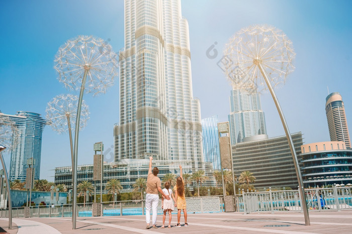 家庭迪拜与摩天大楼的背景视图从后面快乐家庭走迪拜与迪拜塔哈利法塔摩天大楼的背景