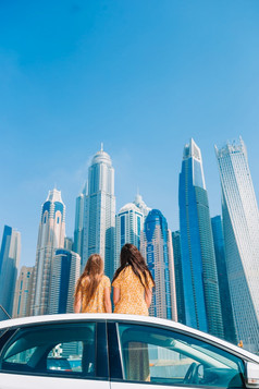 妈妈。和小女孩背景摩天大楼迪拜旅行车夏天车旅行和年轻的家庭假期