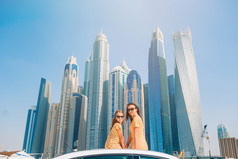 家庭夏天假期妈妈和小女孩车假期背景摩天大楼迪拜夏天车旅行和年轻的家庭假期