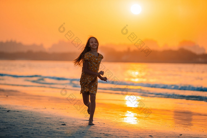 可爱的快乐小女孩的海滩的黎明时间可爱的快乐小女孩白色海滩日落