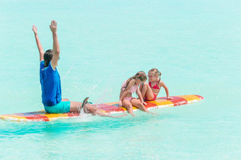 家庭<strong>爸爸</strong>和孩子有有趣的站划在一起的海洋家庭<strong>爸爸</strong>和孩子们冲浪板在夏天假期