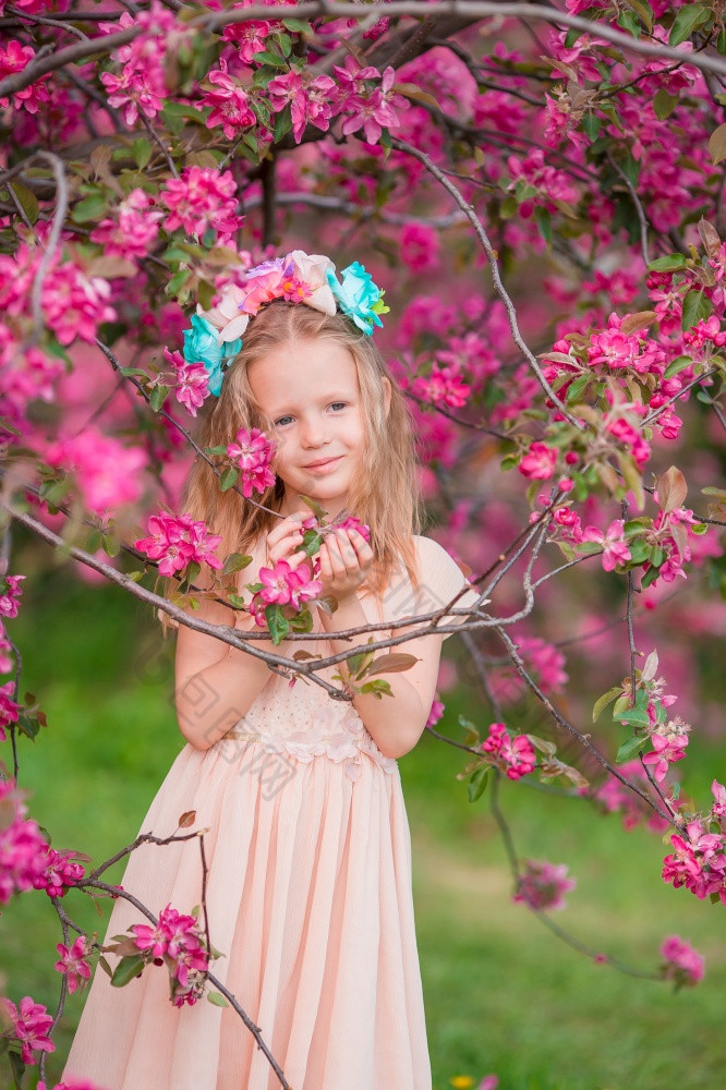 美丽的小女孩盛开的树花园可爱的小女孩盛开的苹果花园美丽的春天一天