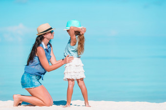 年轻的美丽的妈妈。和她的可爱的小女儿有有趣的热带海滩美丽的妈妈。和女儿加勒比海滩享受夏天假期