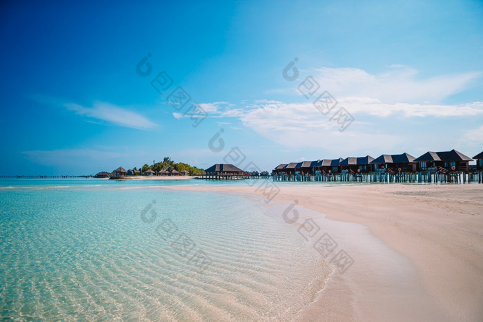 热带海滩马尔代夫与棕榈树和蓝色的环礁湖马尔代夫天堂海滩美丽的海滩与棕榈树和喜怒无常的天空夏天假期旅行假期背景概念马尔代夫天堂海滩